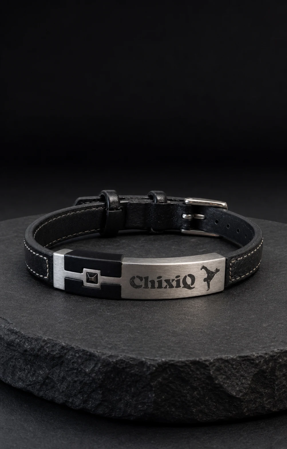 ChixiQ black leather statement bracelet standing on dark stone
